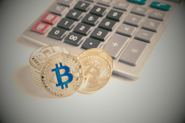 Solo mini mining calculator illustration with a physical calculator and Bitcoin coins